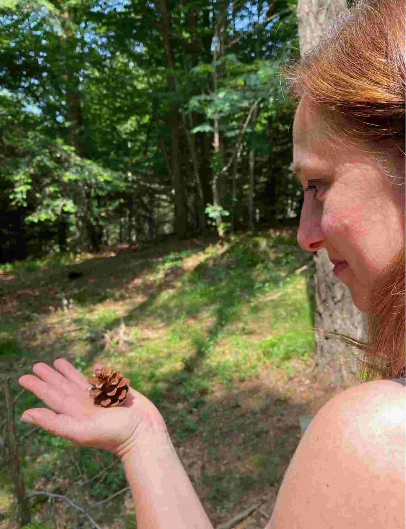 femme qui tient une pomme de pin